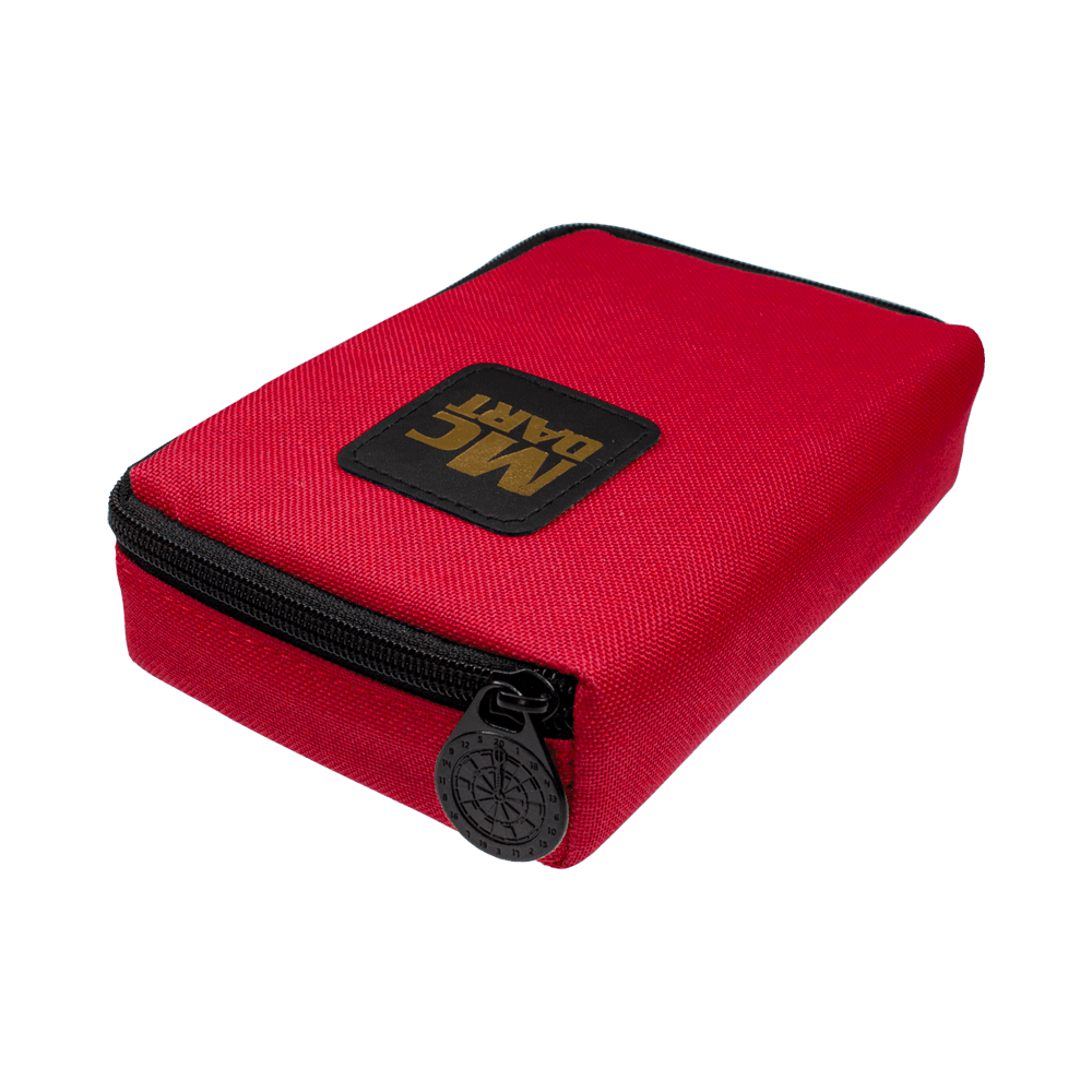 712_McDart_Tasche_Klein_Rot_2 Auf dem Bild ist eine kleine, rote Tasche mit Reißverschluss zu sehen. Auf der Tasche befindet sich ein schwarzes Patch mit der goldenen Aufschrift "MC DART".
