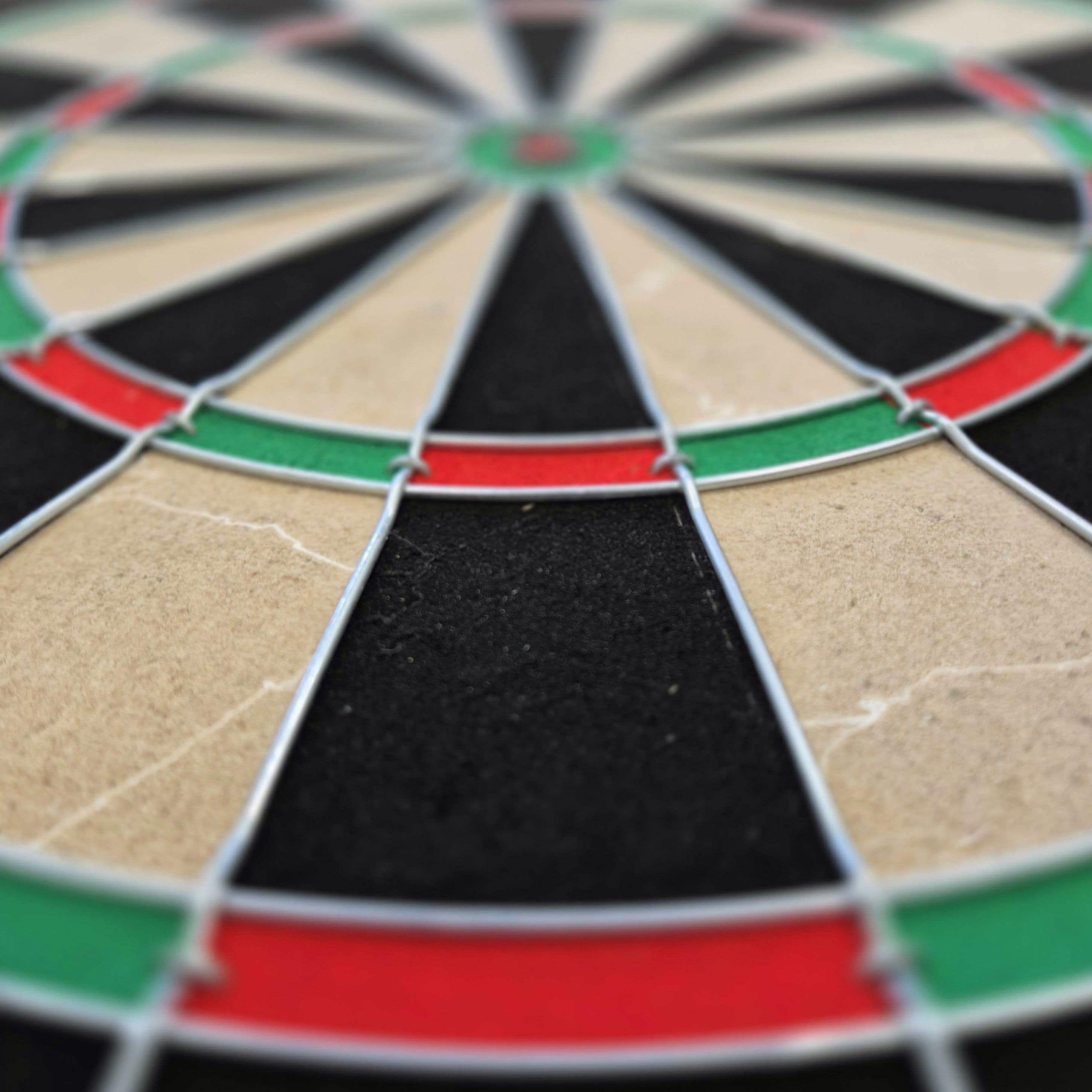 Target Gabriel Clemens steel dartboard set Das Bild zeigt ein Steeldartboard mit farbigen Segmenten in Rot, Grün, Schwarz und Beige. Es handelt sich um das Produkt "Target Gabriel Clemens Steeldartboard Set".