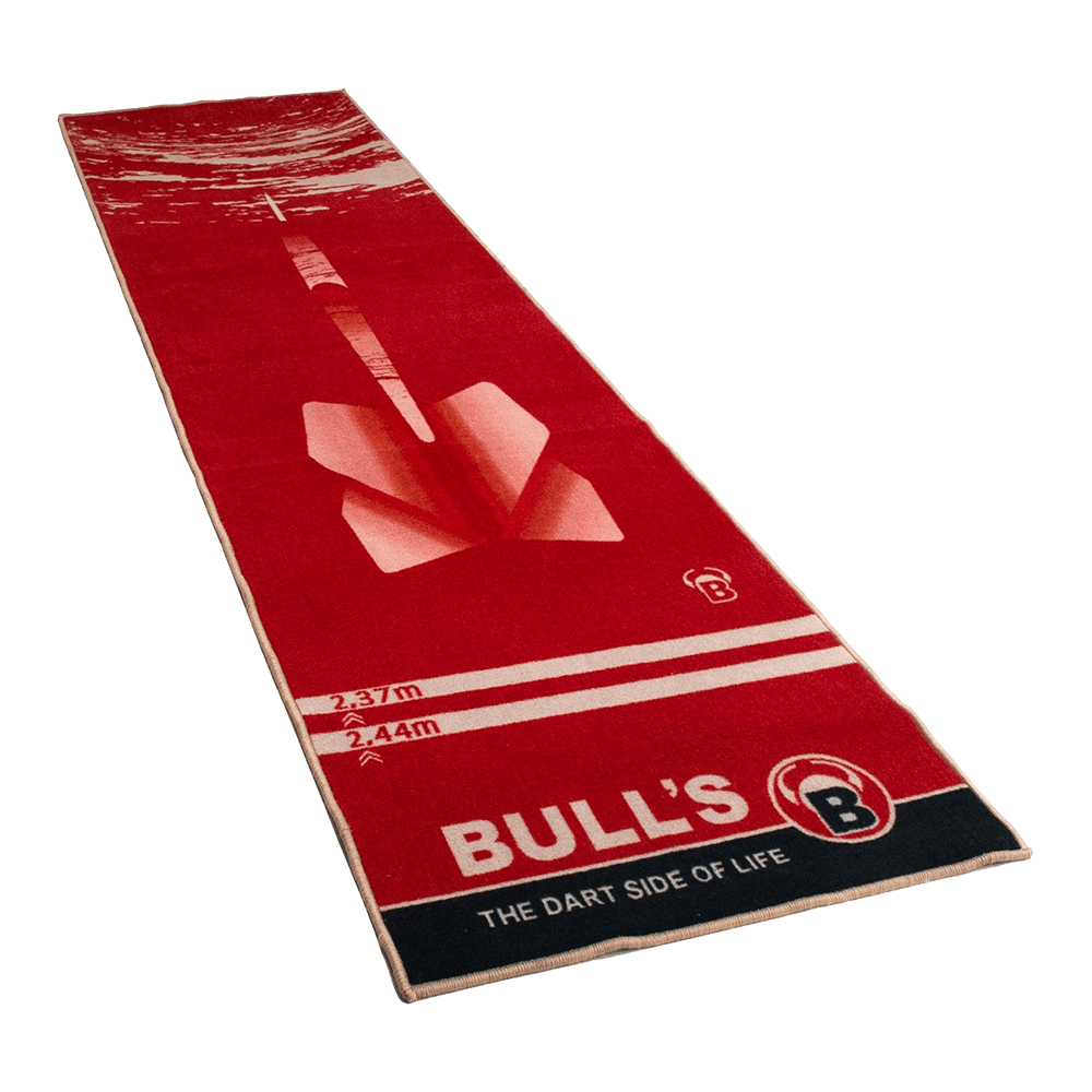 67806_Bulls_Dartteppich_180_Red_1 Dies ist ein roter Teppich mit einem großen Dartpfeil-Motiv in der Mitte. Am unteren Rand steht „BULL'S – THE DART SIDE OF LIFE“.