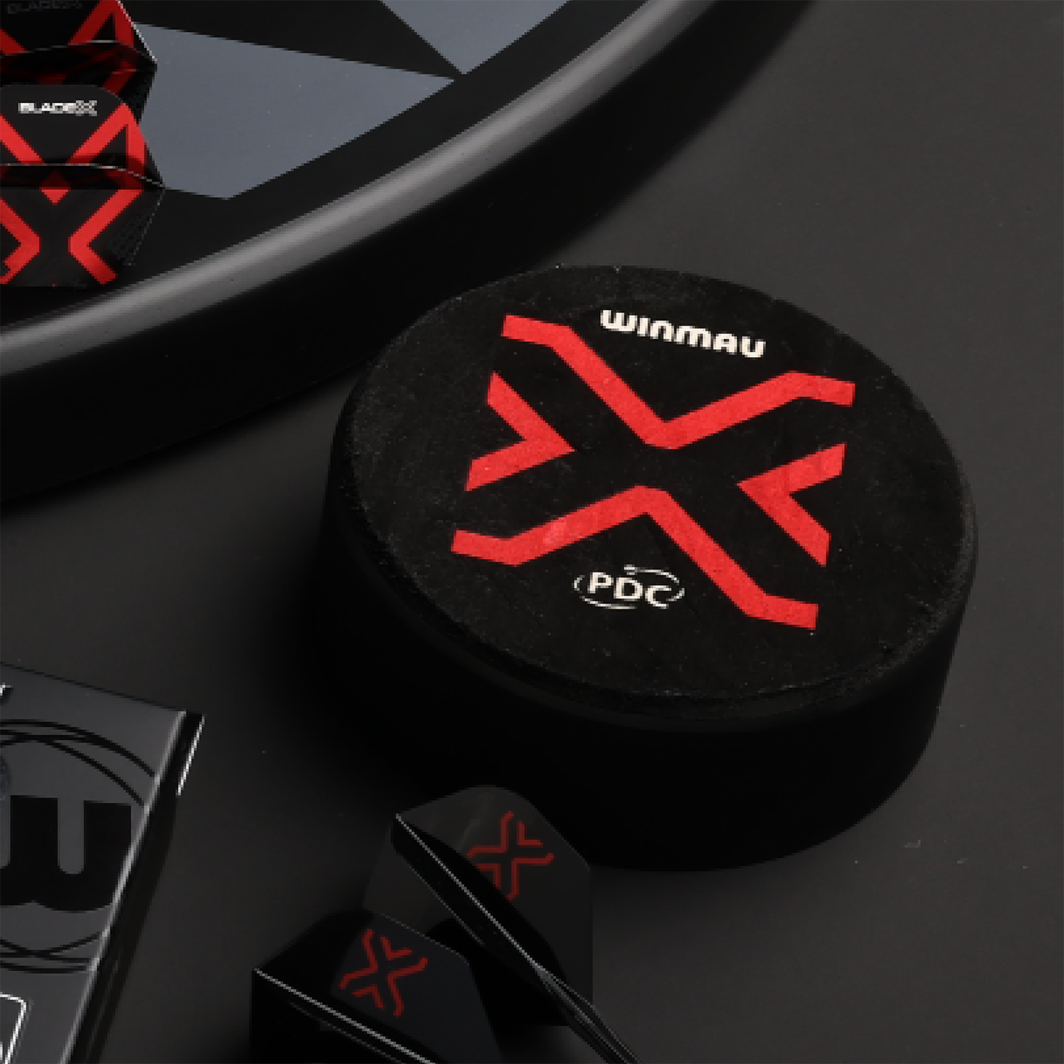 Der Winmau Dart Dock Blade X Dartständer ist auf dem Bild zu sehen. Es handelt sich um einen modernen Dartständer für Dartspieler.