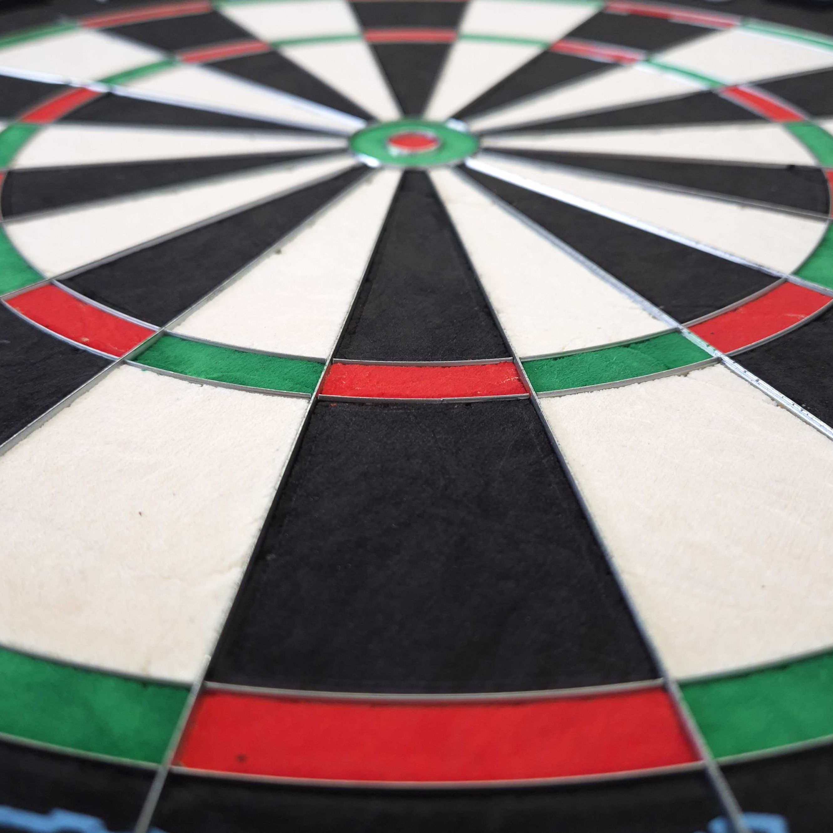 Mission Samurai Infinity steel dartboard Das Bild zeigt eine Nahaufnahme eines Steeldartboards mit klar erkennbaren Farbfeldern in Rot, Grün, Schwarz und Weiß. Es handelt sich um das Produkt "Mission Samurai Infinity Steeldartboard".