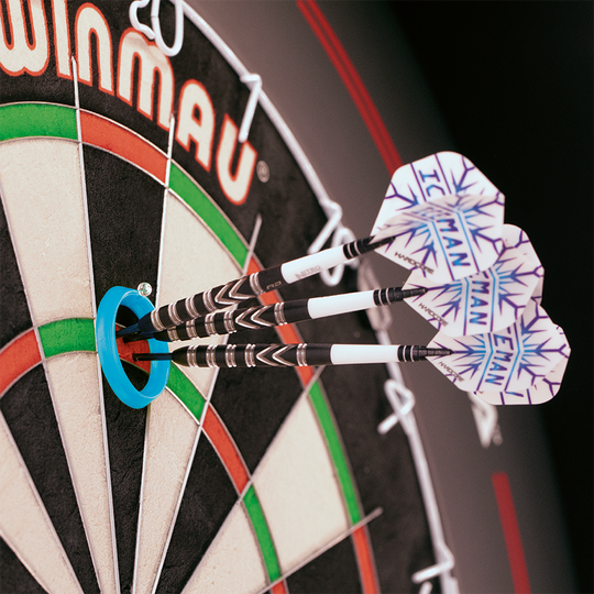 Das Bild zeigt das Produkt "Red Dragon Gerwyn Price Practice Rings" auf einer Dartscheibe. Drei Darts stecken im Bullseye, das von einem blauen Übungsring umgeben ist.