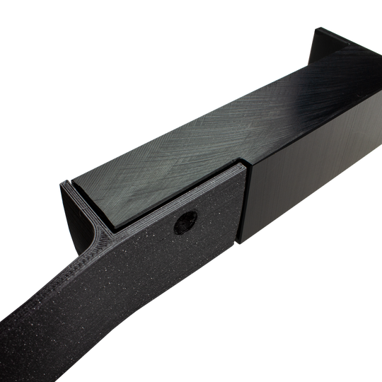 Das Bild zeigt einen schwarzen Abstandshalter zur Wandmontage, der für das Scolia Home 1 System verwendet wird. Das Produkt besteht aus stabilem Material und hat eine rechteckige Form mit einer Befestigungsöffnung.
