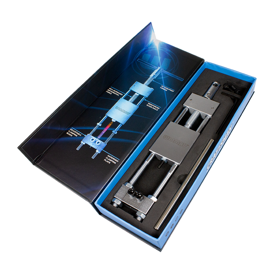 8425-Winmau-Craftsman-Re-pointing-System-5Rw3CTvWlDH1nL Das Bild zeigt das Produkt "Winmau Craftsman Re-Pointing System Spitzenwechsler" in einer geöffneten Verpackung. Das Werkzeug liegt ordentlich in einer Schaumstoffeinlage, daneben ist eine grafische Anleitung zu sehen.