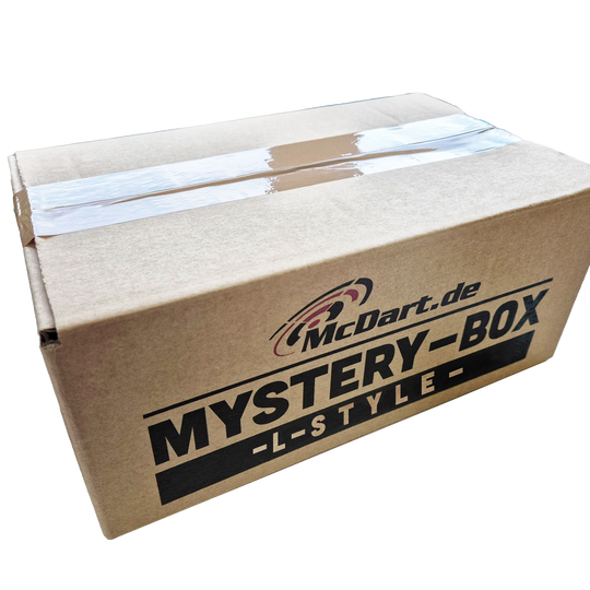 McDart Mystery Box - L-Style Auf dem Bild ist ein brauner Karton mit der Aufschrift „McDart.de MYSTERY-BOX -L-STYLE-“ zu sehen. Die Box ist mit Klebeband verschlossen.